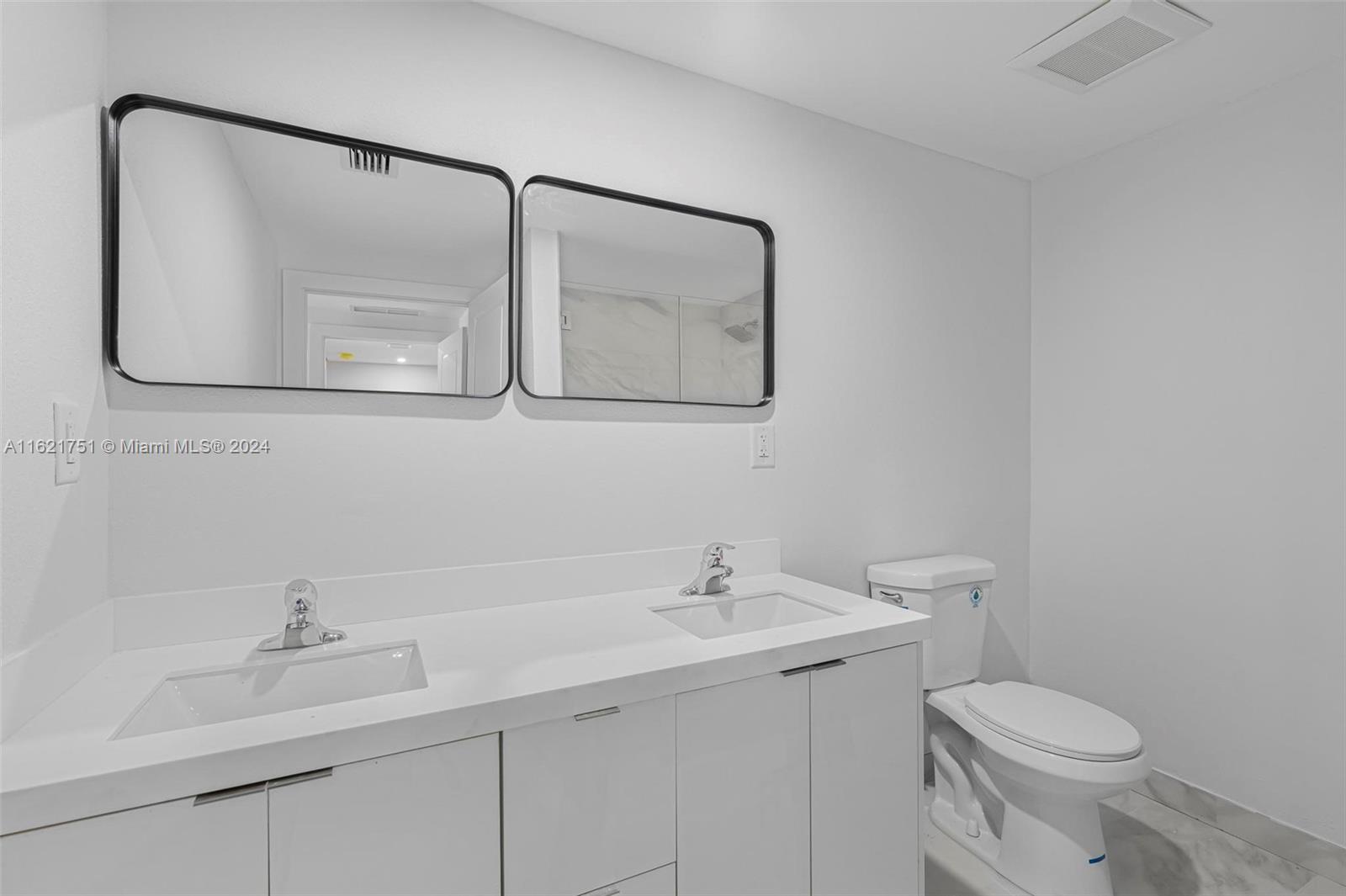 16955 Southwest 100th Avenue Miami, FL 33157 - Photo 30 of 36 a bathroom with a toilet sink and mirror