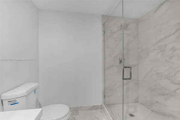 a white toilet sitting next to a bath tub shower
