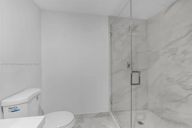 a white toilet sitting next to a bath tub shower