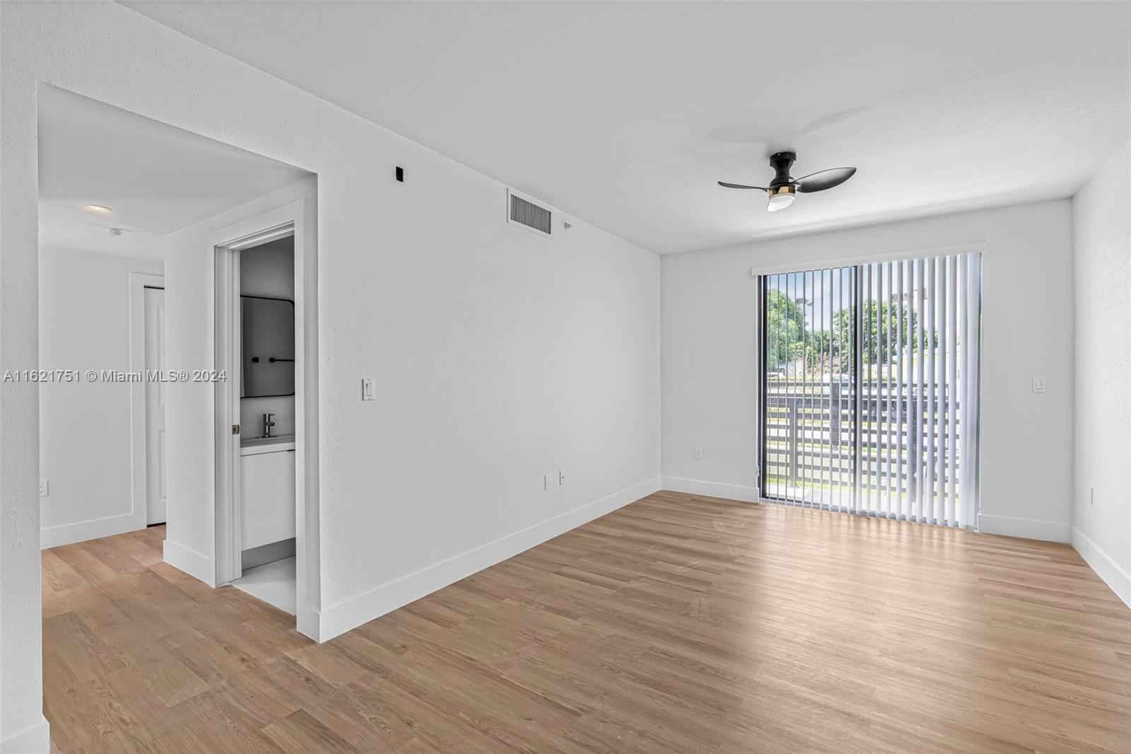 16955 Southwest 100th Avenue Miami, FL 33157 - Photo 7 of 36 a view of an empty room with wooden floor and a window
