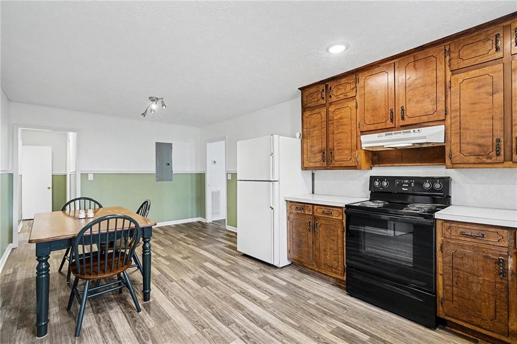 360 Ridge Road Canton, GA 30114 - Photo 9 of 16 a kitchen with stainless steel appliances granite countertop a stove top oven a refrigerator a dining table and chairs with wooden floor