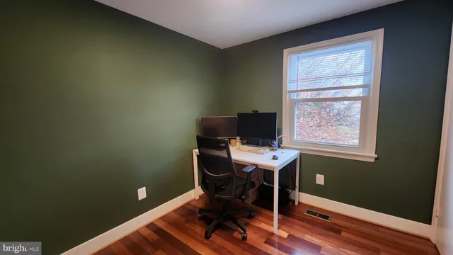 a view of a workspace with furniture and a window