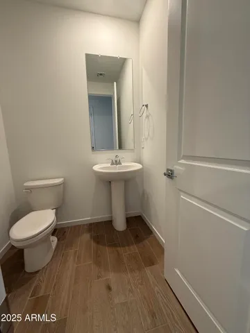a bathroom with a toilet a sink and mirror