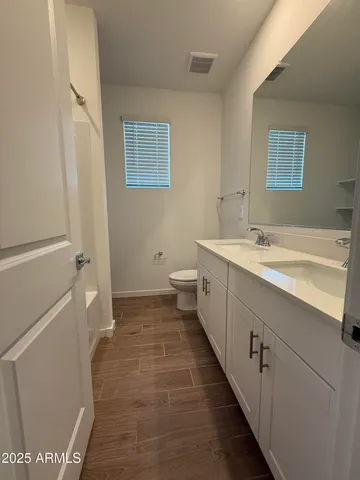 a bathroom with a sink a toilet and a mirror