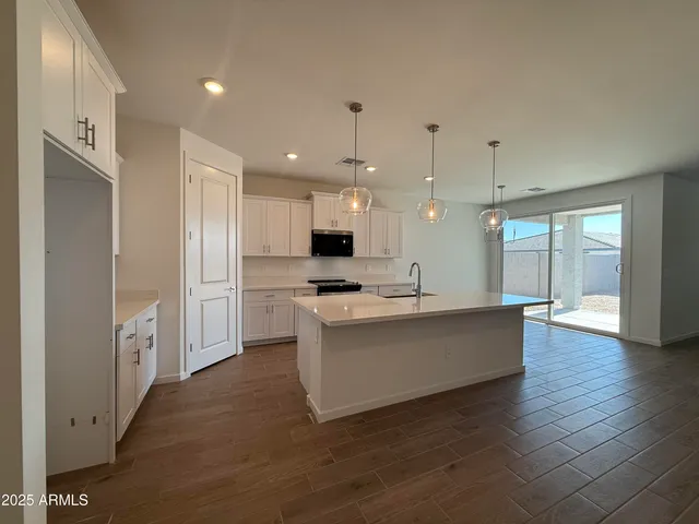 a large white kitchen with a large window stainless steel appliances
