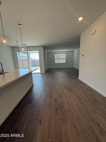 a view of a big room with wooden floor and windows
