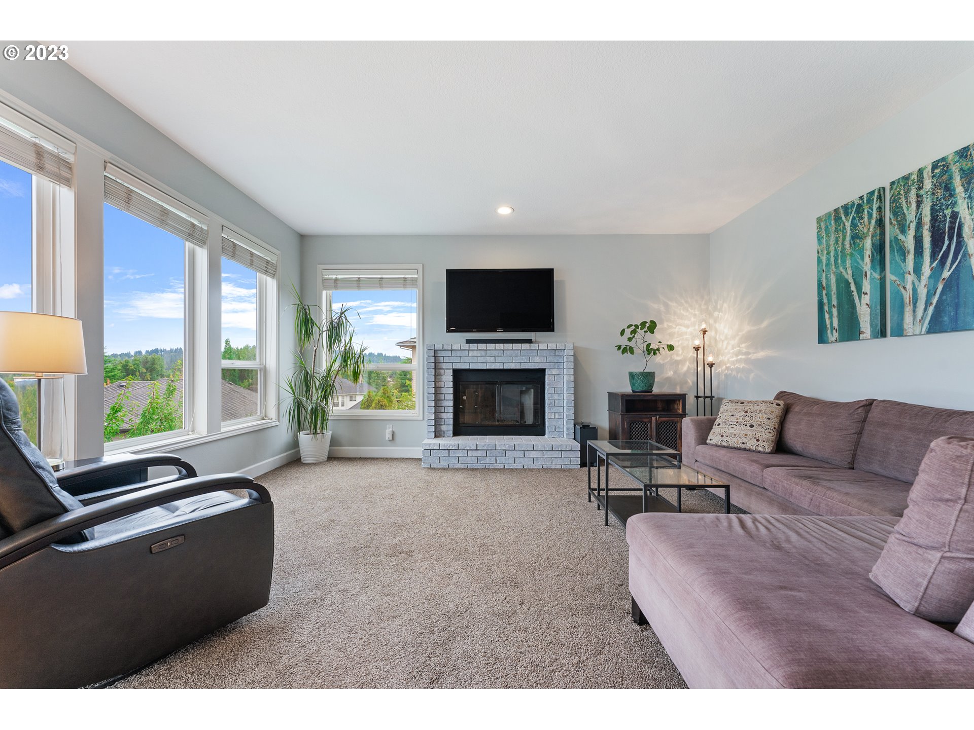 11561 Southeast Highland Loop Clackamas, OR 97015 - Photo 12 of 36 a living room with furniture flat screen tv and a fireplace