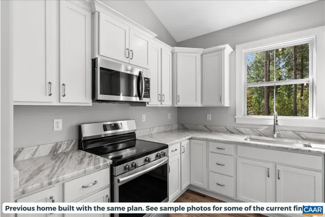 a kitchen with stainless steel appliances granite countertop a sink stove and microwave