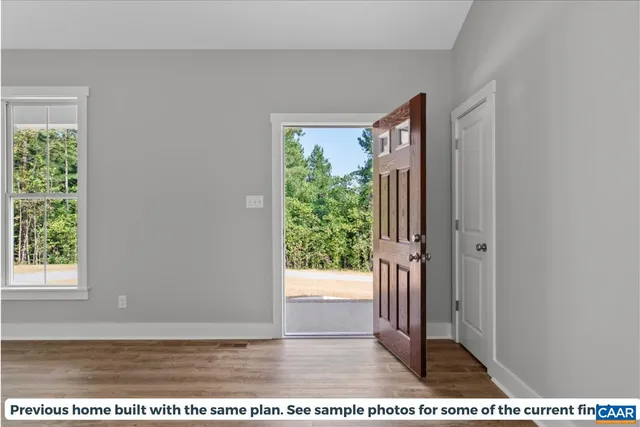 a view of a hallway with wooden floor and a window