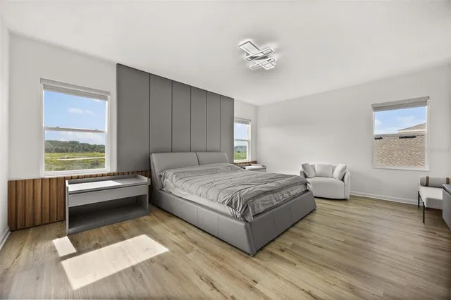 a spacious bedroom with a bed and a chandelier