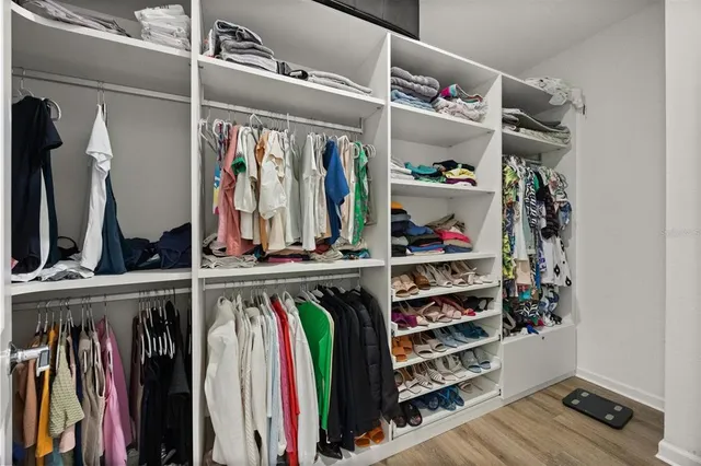 a view of walk in closet with clothes and shoes