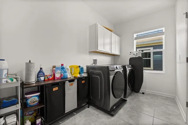 a utility room with fridge dryer and washer