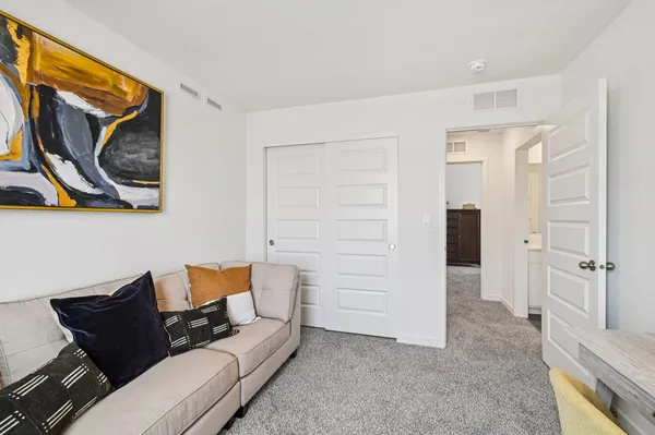 a living room with furniture and a painting on the wall