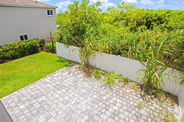 a view of a patio with table and chairs and potted plants