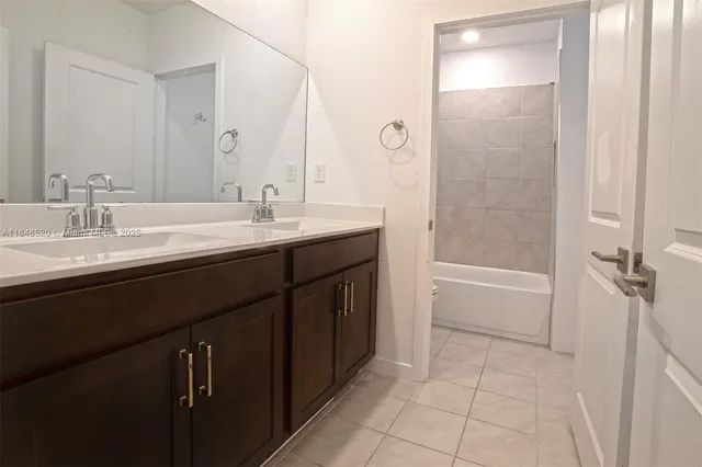 a spacious bathroom with a granite countertop sink a mirror and a bathtub