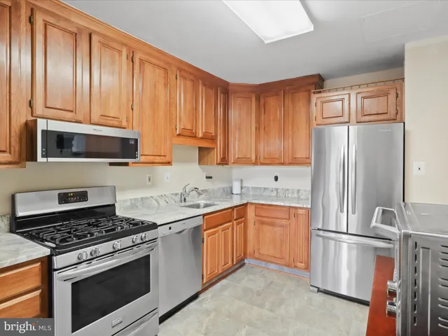 a kitchen with stainless steel appliances granite countertop a stove a refrigerator and a sink