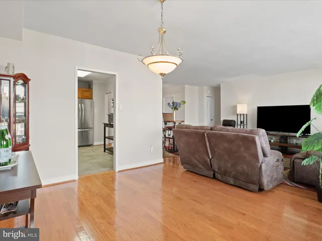 a living room with furniture a flat screen tv and a chandelier