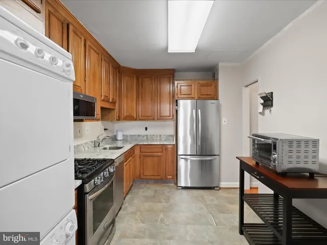 a kitchen with stainless steel appliances granite countertop a refrigerator stove and sink