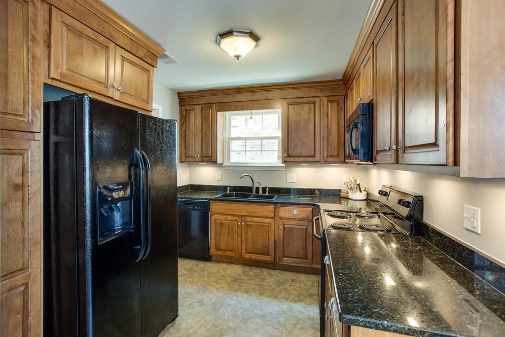 1250 General George Patton Road Nashville, TN 37221 - Photo 9 of 27 a kitchen with granite countertop stainless steel appliances a sink stove refrigerator and a window