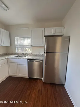 a kitchen with a refrigerator a sink and a stove top oven