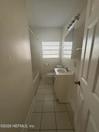 a bathroom with a sink toilet and window