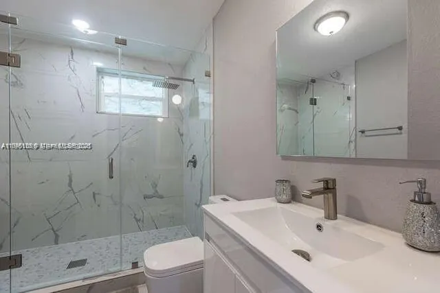 a bathroom with a sink toilet and shower