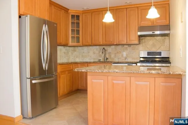 a kitchen with stainless steel appliances granite countertop a refrigerator and a sink
