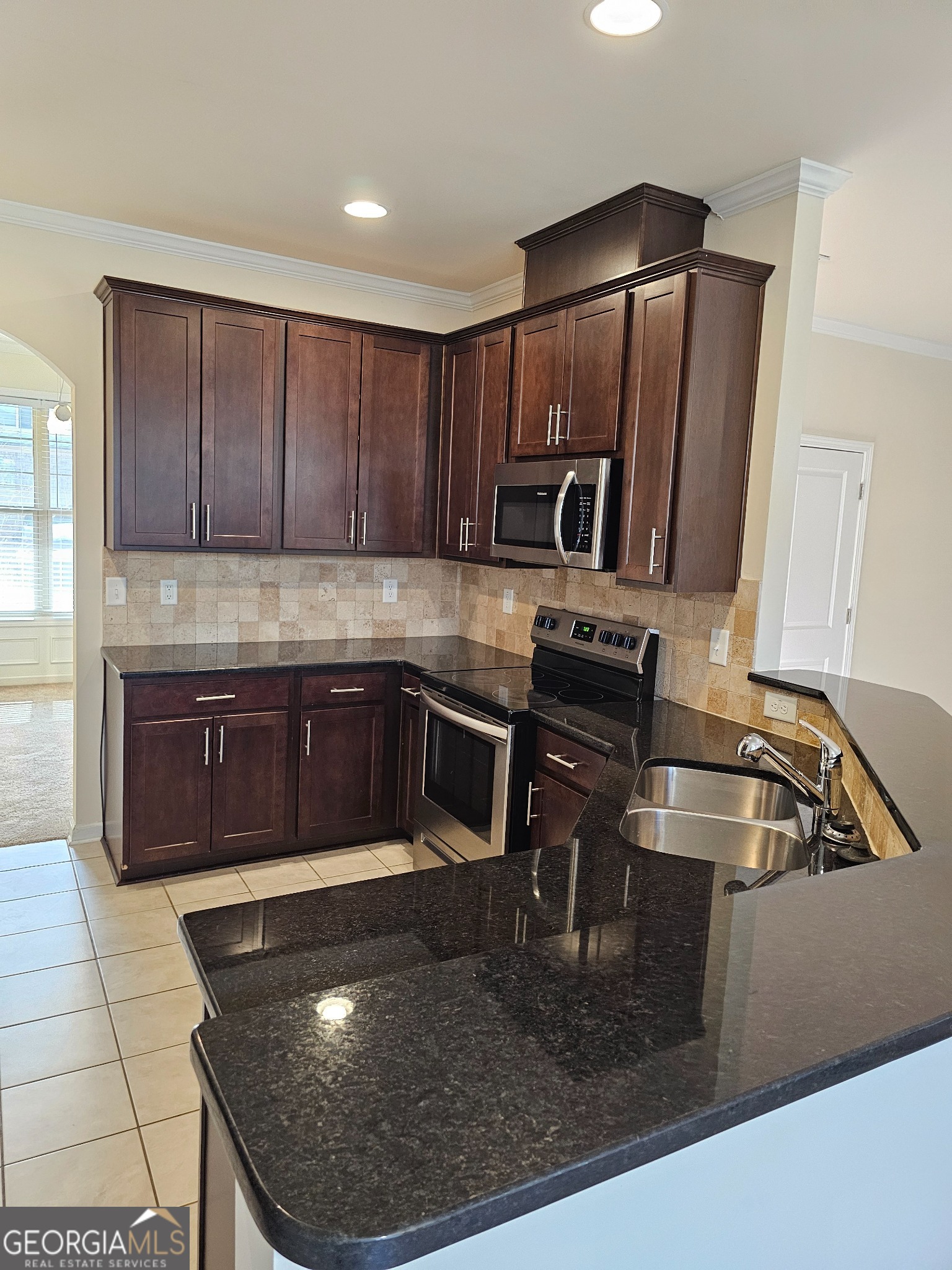 6509 Panasa Court Norcross, GA 30093 - Photo 2 of 16 a kitchen with kitchen island granite countertop a sink and a stove
