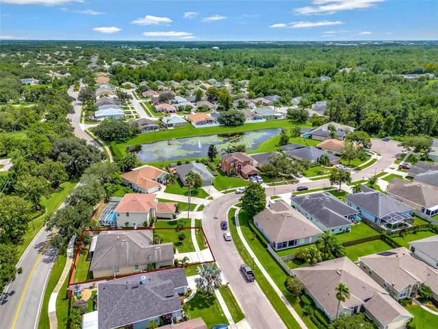 an aerial view of ocean and residential houses with outdoor space