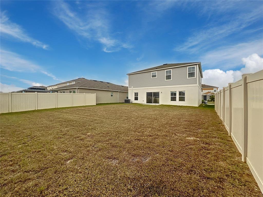 1404 Axel Circle Winter Haven, FL 33880 - Photo 20 of 21 a big house with a big yard and large trees