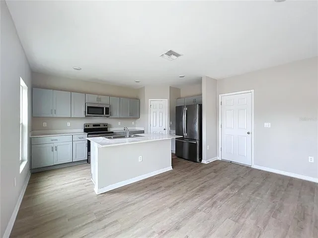 a kitchen with stainless steel appliances a refrigerator and a stove top oven