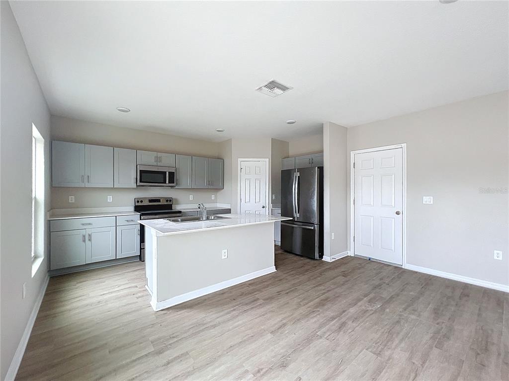 1404 Axel Circle Winter Haven, FL 33880 - Photo 6 of 21 a kitchen with stainless steel appliances a refrigerator and a stove top oven