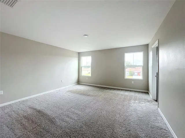 a view of a big room with windows and chandelier fan