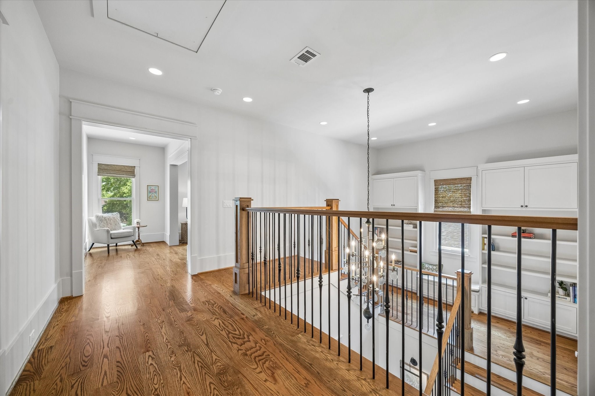 1101 Omar Street Houston, TX 77009 - Photo 25 of 46 The expansive upstairs landing connects the home’s secondary bedrooms and living spaces with warmth and functionality, featuring natural light, hardwood floors, custom built-ins, and flexible space for reading, studying, or everyday gathering.