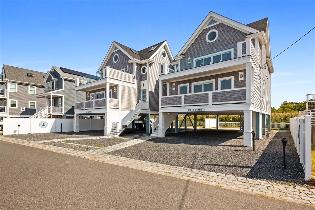 137 Wessagussett Road Weymouth, MA 02191 - Photo 31 of 32 a view of a big house with large windows and a yard