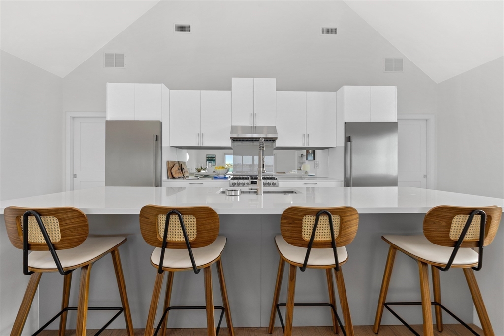 137 Wessagussett Road Weymouth, MA 02191 - Photo 6 of 32 a kitchen with stainless steel appliances granite countertop a dining table chairs and a refrigerator