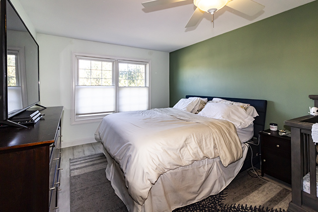936 Chase Court Gurnee, IL 60031 - Photo 10 of 15 a bedroom with a bed and a flat tv screen on the dresser