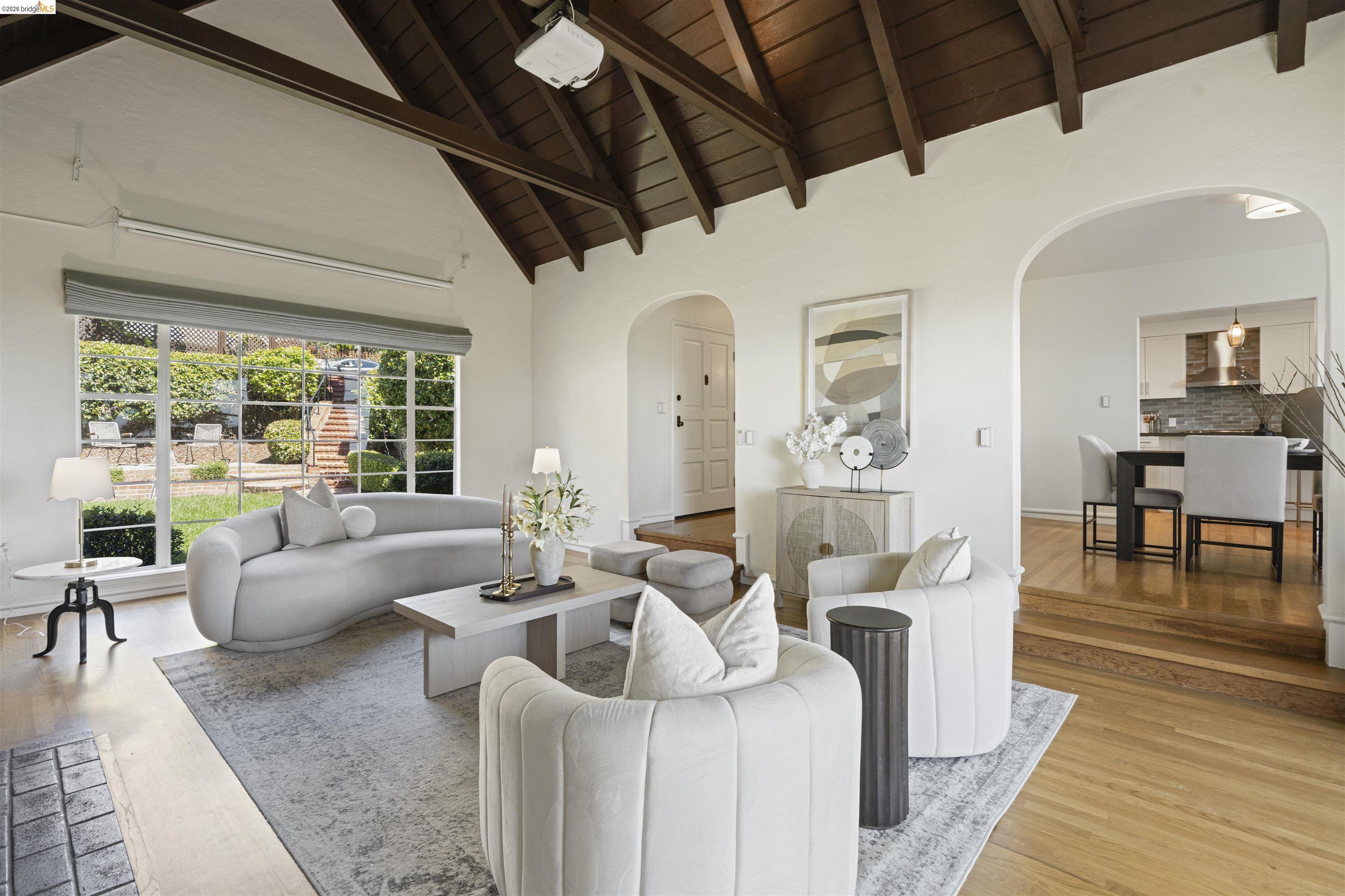 1170 Sterling Avenue Berkeley, CA 94708 - Photo 6 of 52 Living area featuring arched walkways, light wood-type flooring, and a high wood beamed ceiling