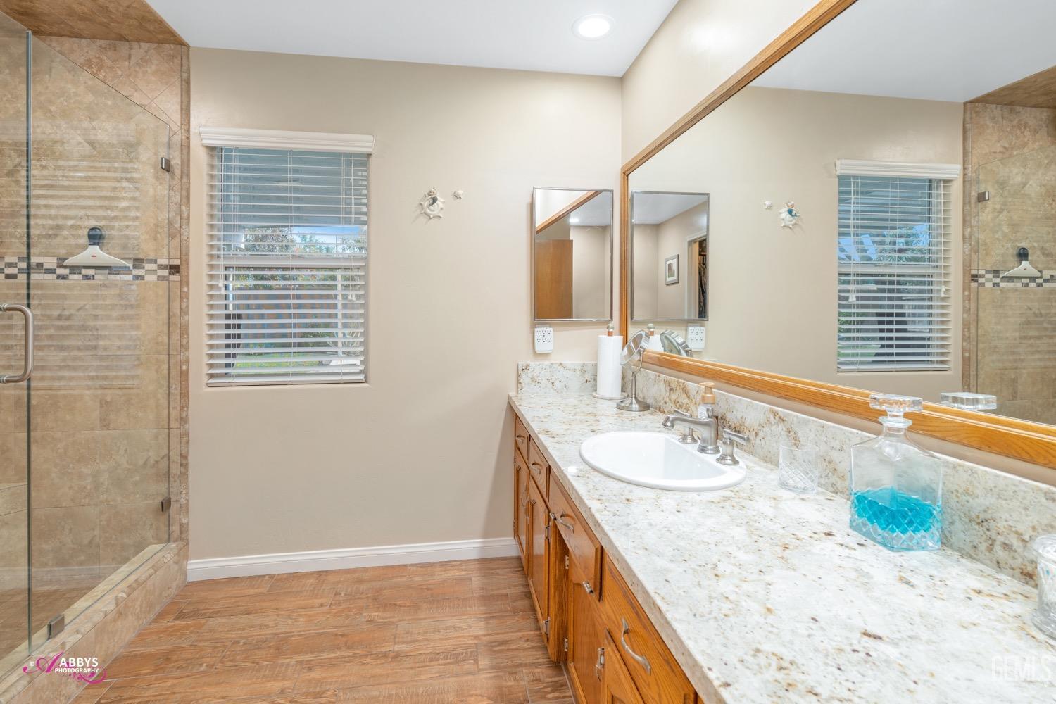 Undisclosed Address Bakersfield, CA 93312 - Photo 19 of 26 a bathroom with a granite countertop sink and a large mirror