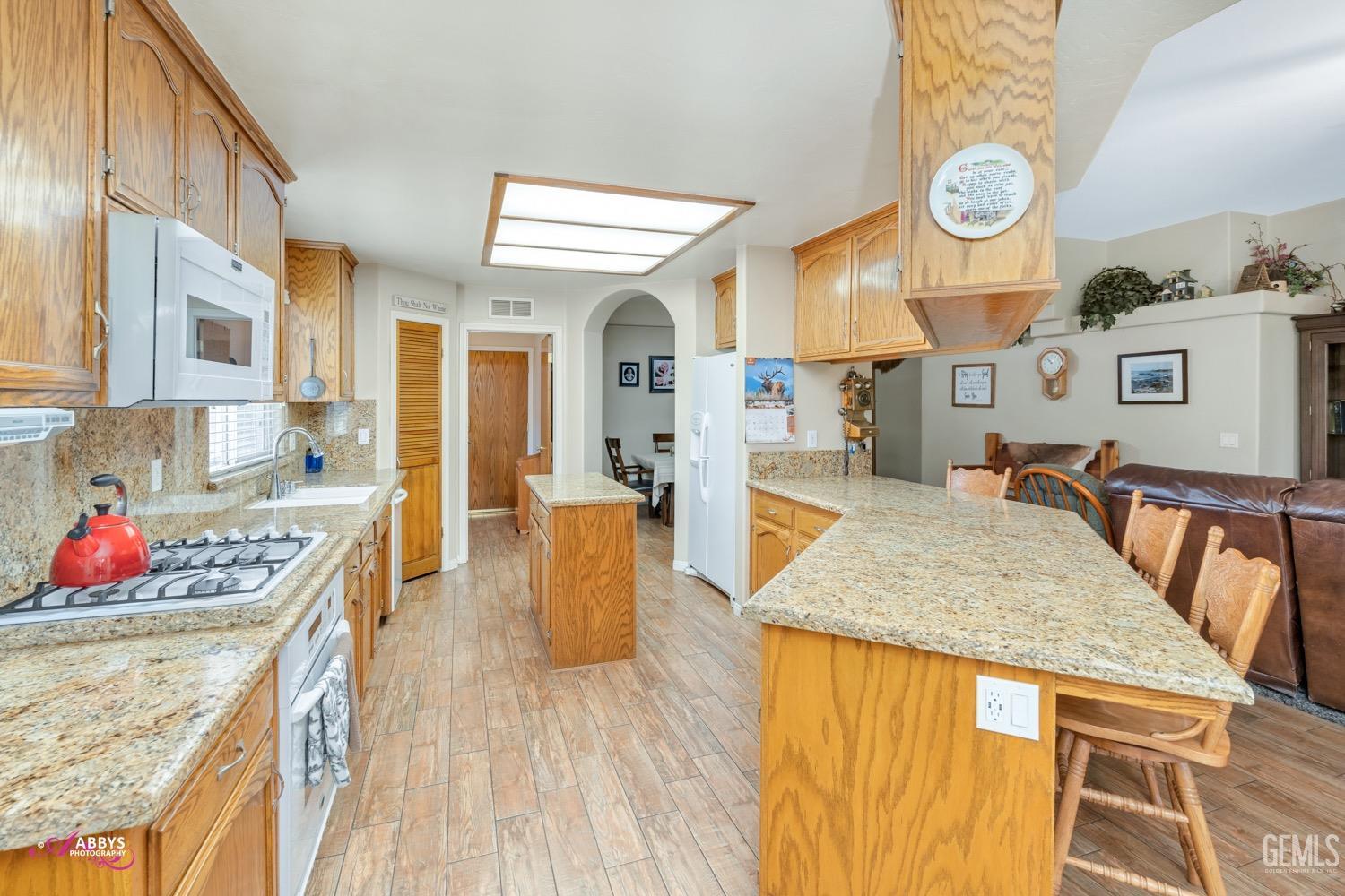 Undisclosed Address Bakersfield, CA 93312 - Photo 9 of 26 a open kitchen with stainless steel appliances granite countertop a stove and a dining table with painted walls
