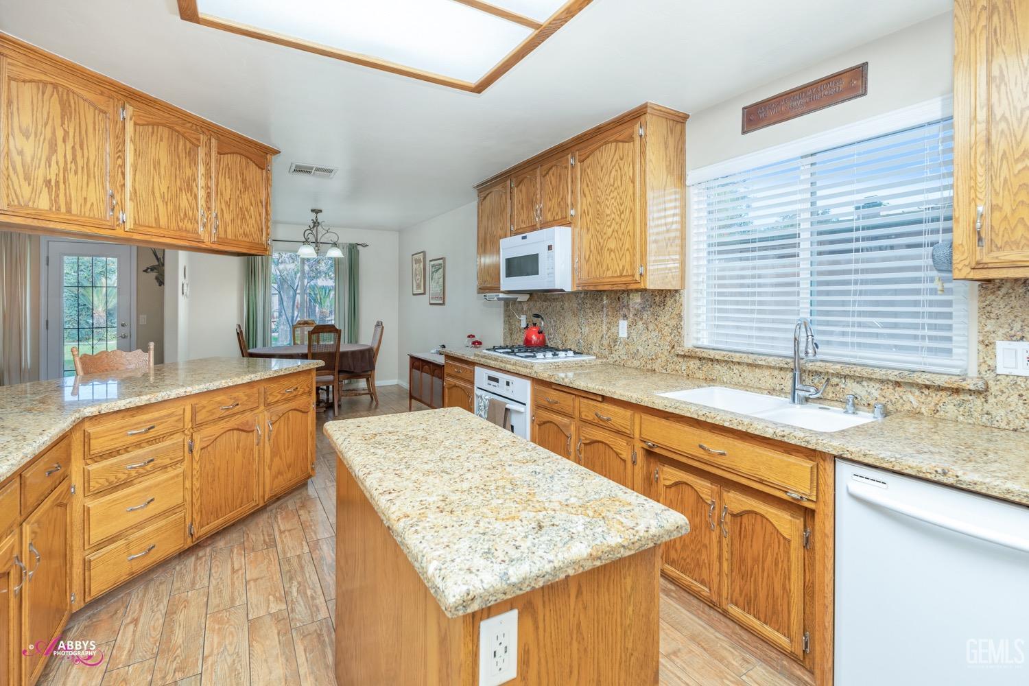 Undisclosed Address Bakersfield, CA 93312 - Photo 10 of 26 a kitchen with stainless steel appliances granite countertop wooden cabinets a sink and a granite counter tops and a large window