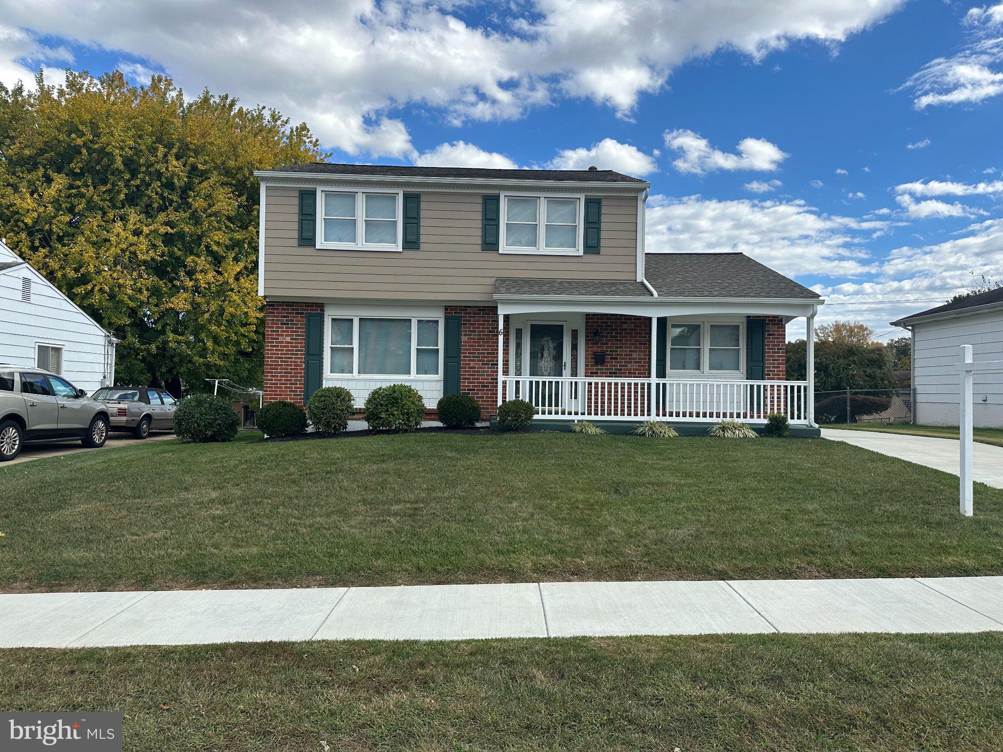 Charming two-story home with greenery.