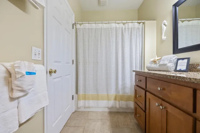 a bathroom with a granite countertop sink and a bathtub