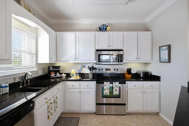 a kitchen with white cabinets sink and white appliances