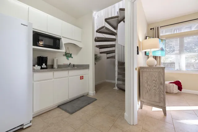 a kitchen with stainless steel appliances kitchen island granite countertop a refrigerator and a sink