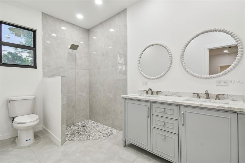 406 Border Street Port Charlotte, FL 33953 - Photo 15 of 20 a bathroom with a toilet a sink a mirror and a shower