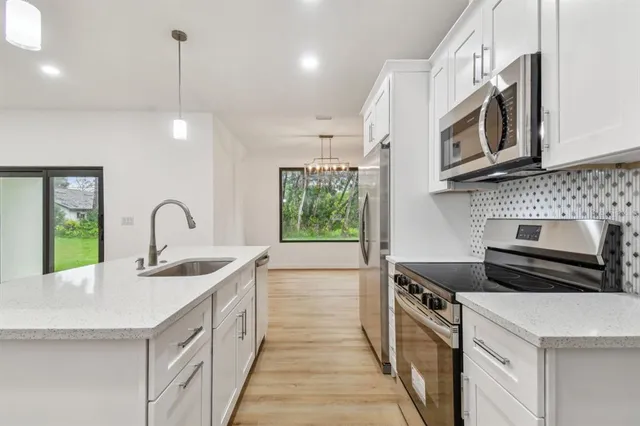 a kitchen with kitchen island a sink stainless steel appliances and cabinets
