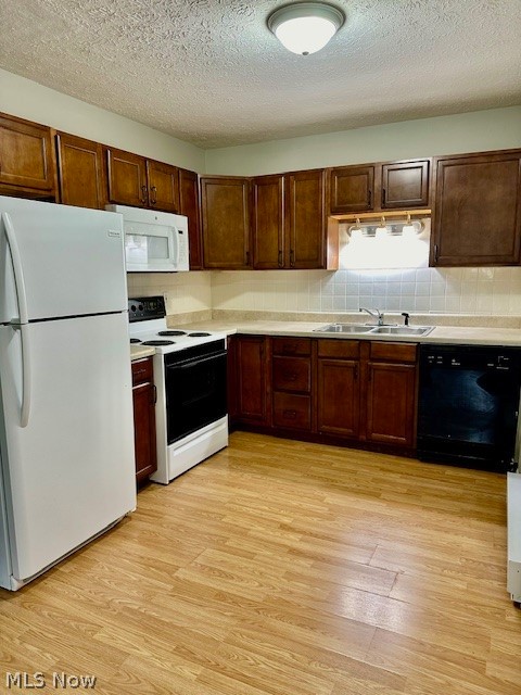 4376 Darrow Road, Unit 7 Stow, OH 44224 - Photo 4 of 23 Kitchen featuring a textured ceiling, light hardwood / wood-style floors, sink, decorative backsplash, and white appliances