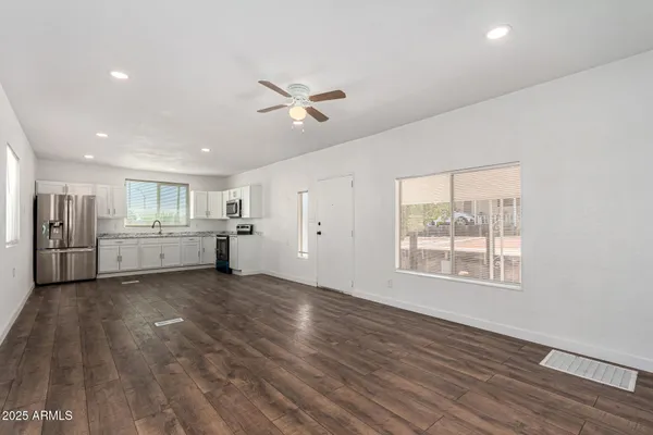 a view of an empty room with a window and wooden floor