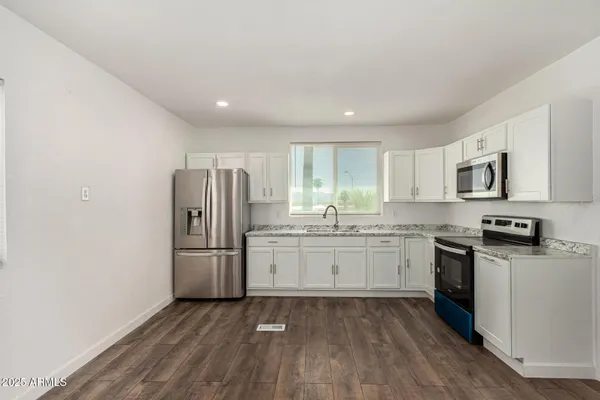 a kitchen with granite countertop appliances cabinets and a sink